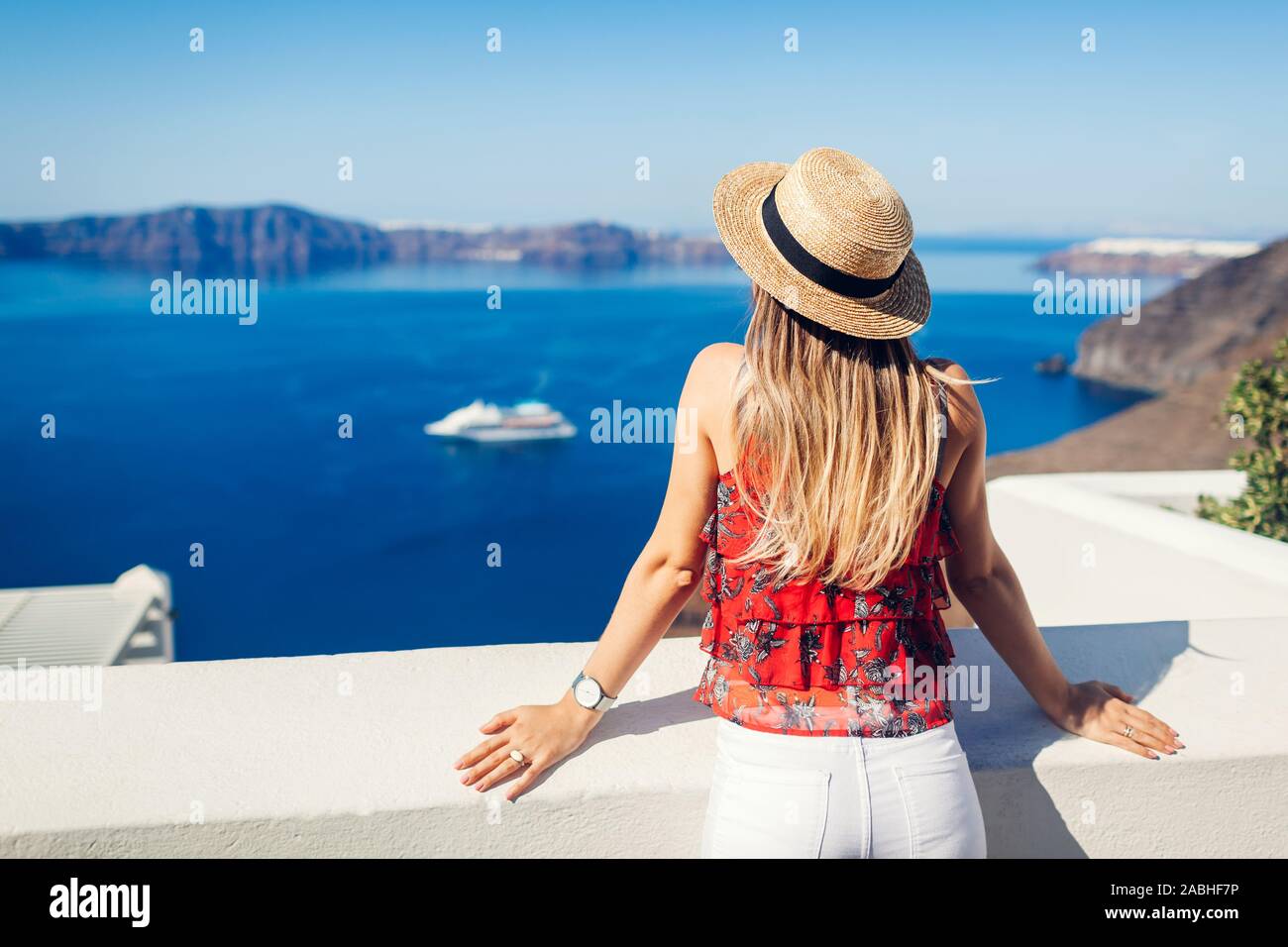 Mujer mirando viajero caldera de Fira o Thera, la isla de Santorini, Grecia. Turismo, viajes, vacaciones, concepto Foto de stock