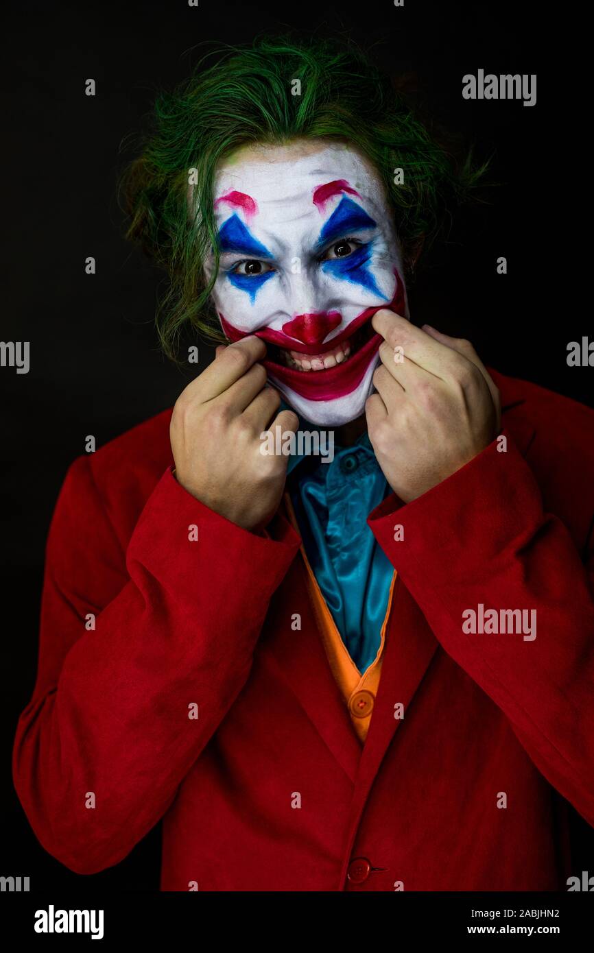 Hombre suplantando al Joker. Retrato de un hombre sonriente con un Joker  maquillaje Fotografía de stock - Alamy