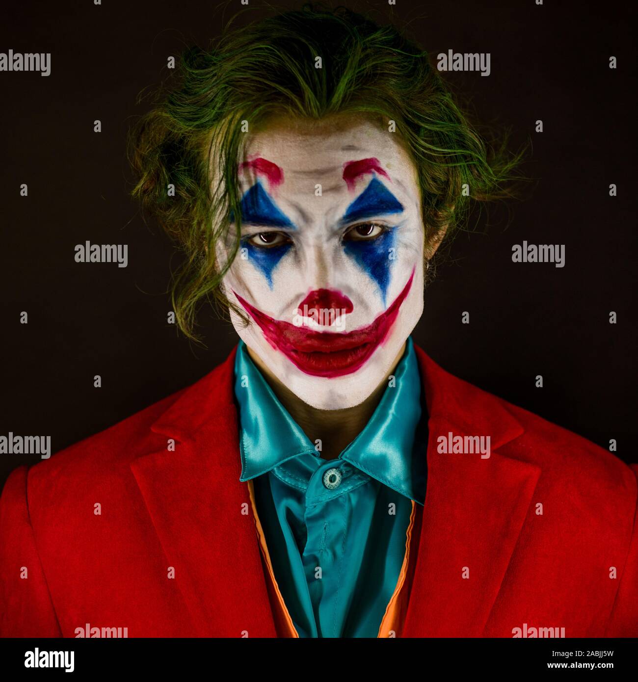 Hombre suplantando al Joker. Retrato de un hombre con un traje de payaso  con maquillaje y cabello verde. Joker cosplay Fotografía de stock - Alamy