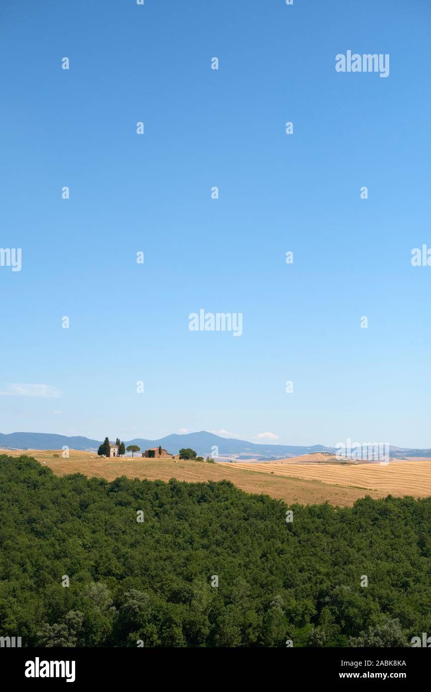 Una vista lejana de la capilla Madonna di Capella Vitaleta y el verano campiña toscana paisaje de la Val d'Orcia, Pienza, Toscana, Italia Europa Foto de stock