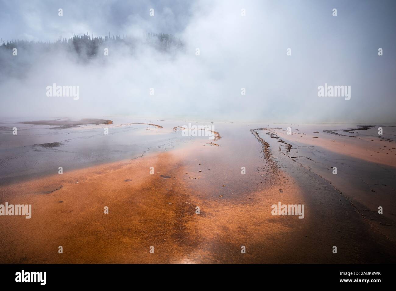 Cubierto de humo naranja el estanque de Grand Prismatic Spring, famoso geyser basin en el Parque Nacional Yellowstone, Wyoming, Estados Unidos. Foto de stock