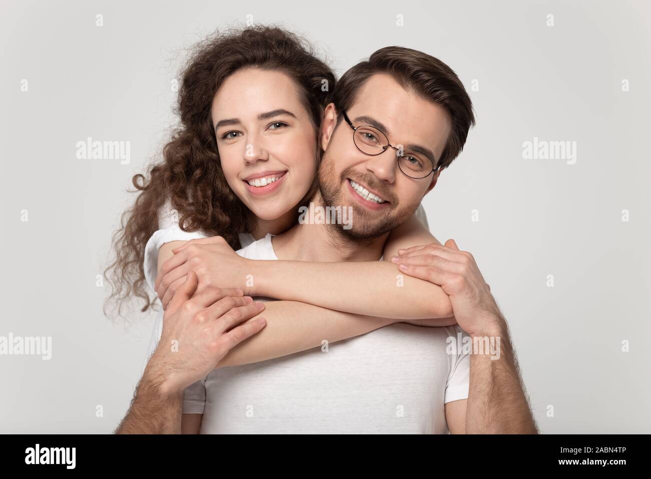 Retrato de la feliz pareja enamorada posando mirando a la cámara Foto de stock