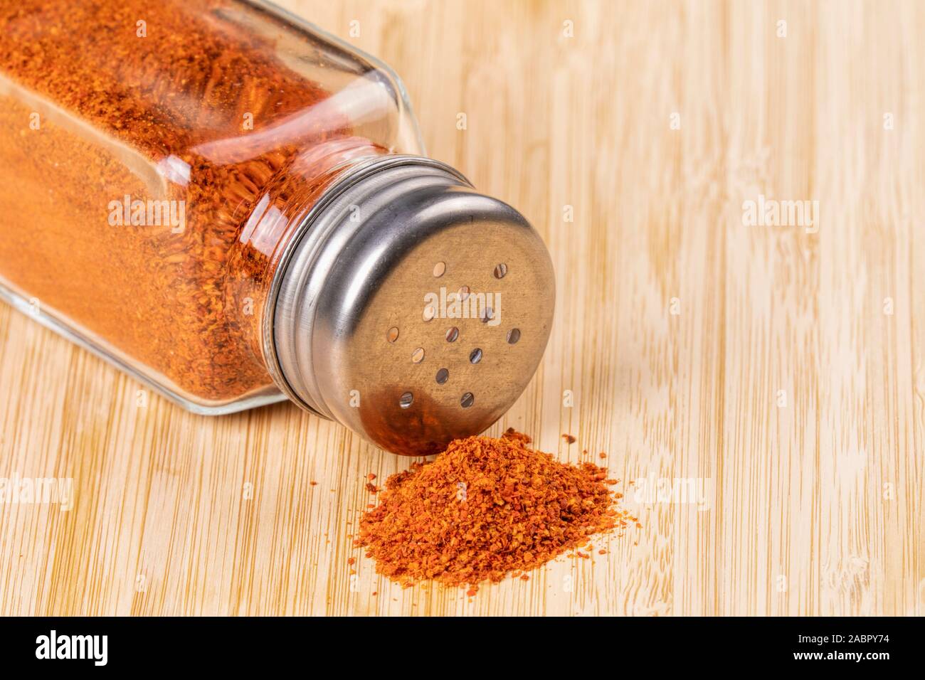 Pepper Shaker de pimienta pimienta roja sobre un fondo de madera Foto de stock