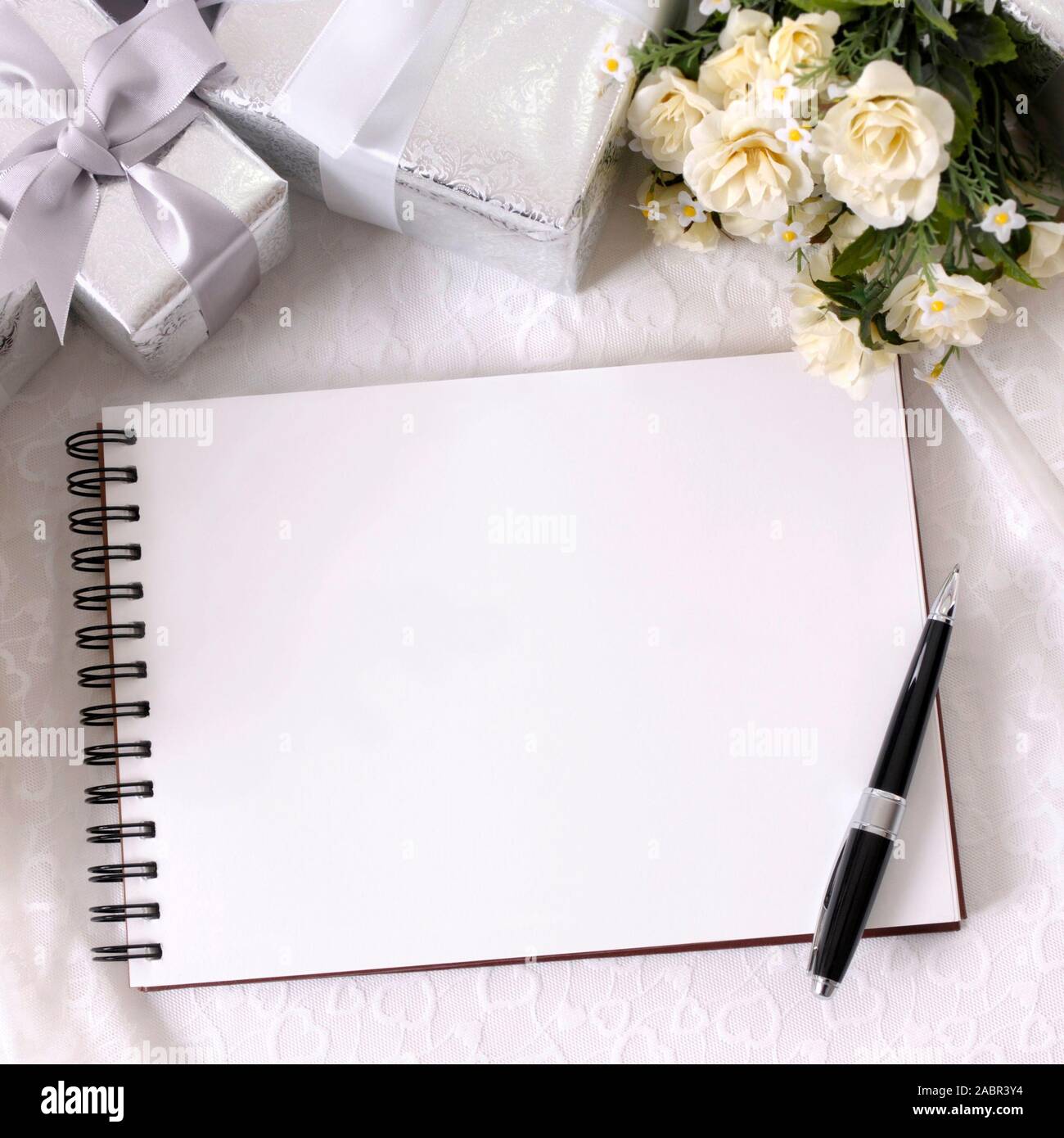 Álbum de bodas o escribir libro sentado en encaje nupcial con varios  regalos de bodas de plata y rosa blanca ramos. Espacio para copiar  Fotografía de stock - Alamy