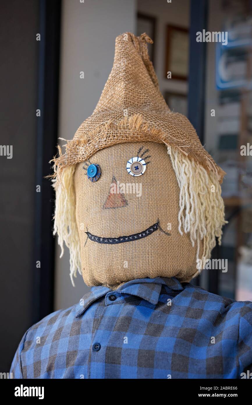 Una paja llenó el espantapájaros, llevaba una gorra de arpillera sentado  afuera de una tienda para dar la bienvenida a los clientes Fotografía de  stock - Alamy