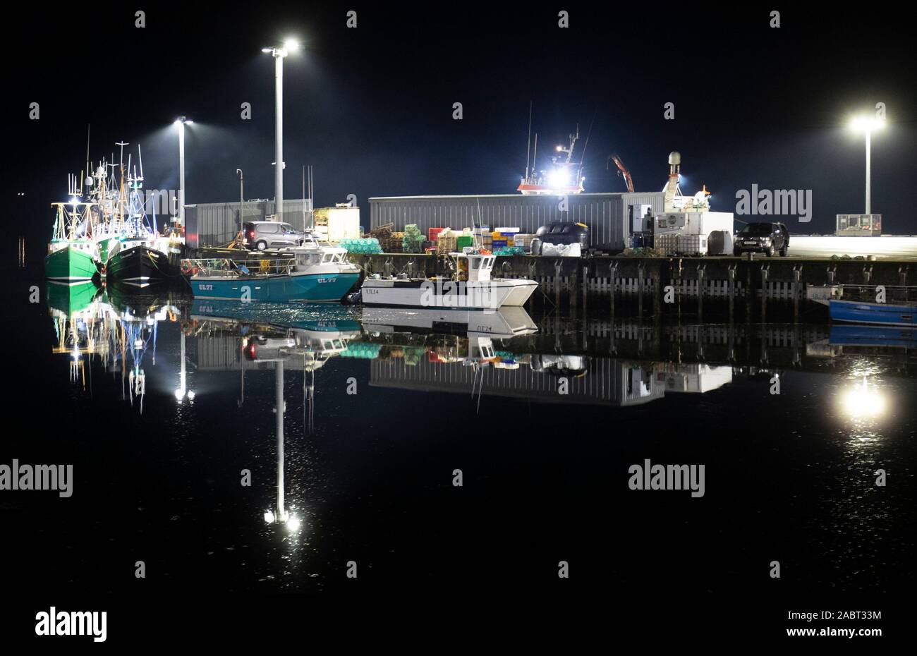 Ullapool puerto por la noche se reflejan en las tranquilas aguas de Loch, Ullapool, Wester Ross. PA la foto. Imagen Fecha: jueves 28 de noviembre de 2019. Crédito de la foto debe leer: Jane Barlow/PA Cable Foto de stock