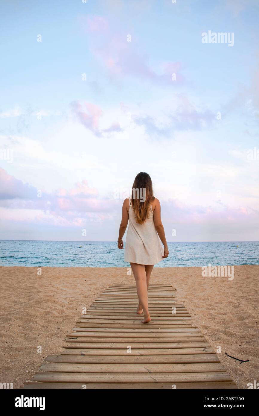 Hermoso paisaje de una chica en su espalda caminando por la playa  Fotografía de stock - Alamy
