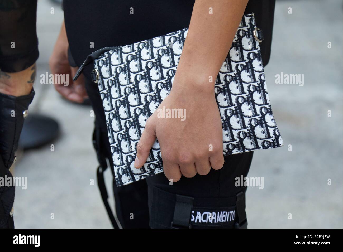 Milán, Italia - 19 de septiembre de 2019: el hombre de negro y blanco bolso  Dior antes de Bottega Veneta Fashion Show, la Semana de la moda de Milán  street style Fotografía