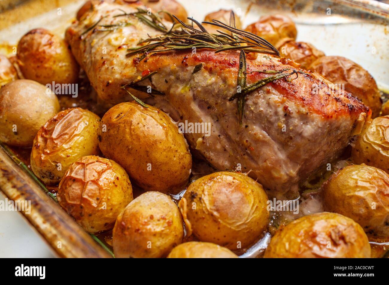 Mostaza con miel lomo de cerdo asado con patatas y bebé rosemary adorne en  horno cazuela Fotografía de stock - Alamy