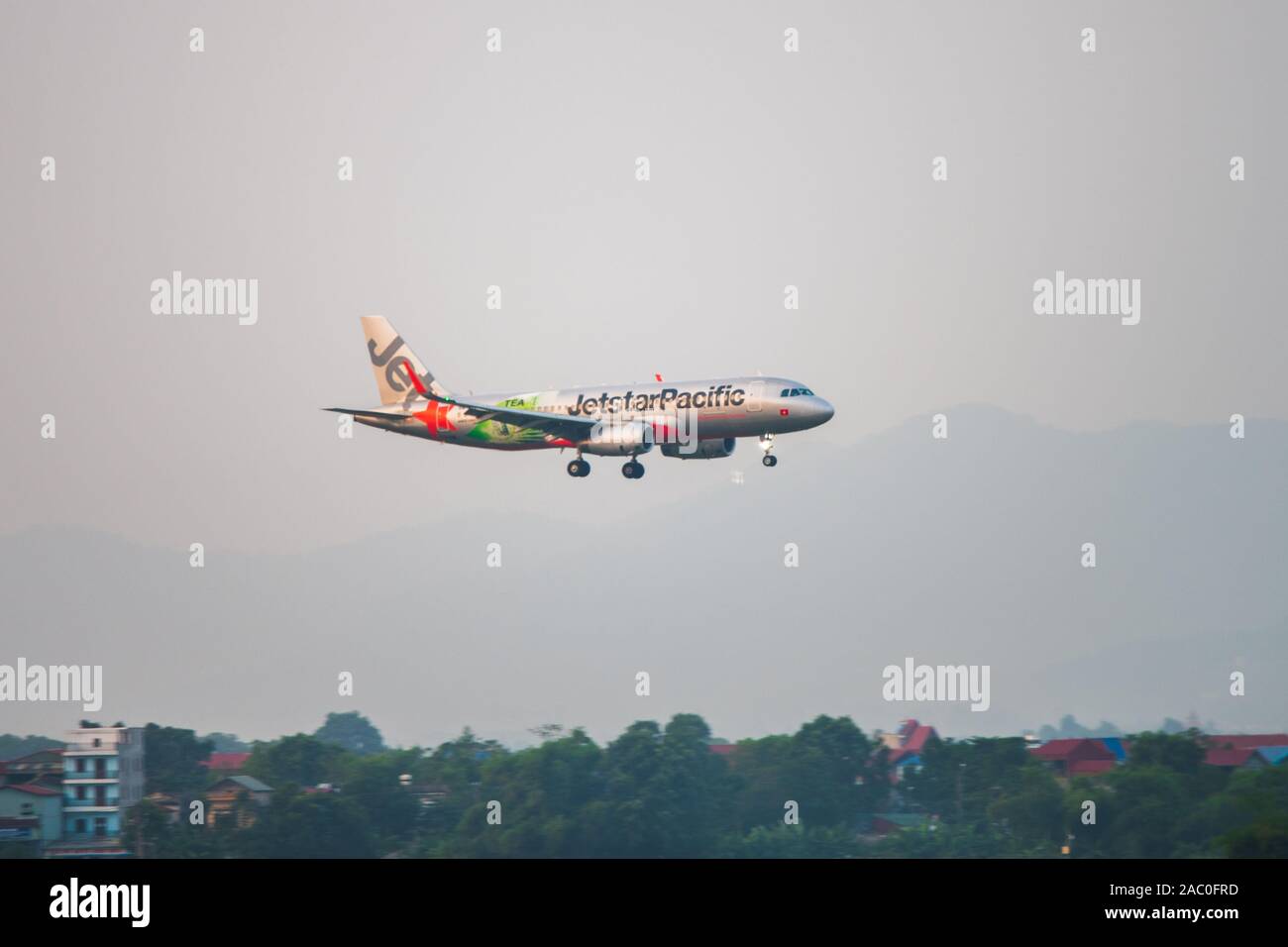 Hanoi, Vietnam - 23 de octubre de 2019: Un Jetstar Pacific avión se prepara para aterrizar en el aeropuerto internacional de Hanoi durante la puesta de sol Foto de stock