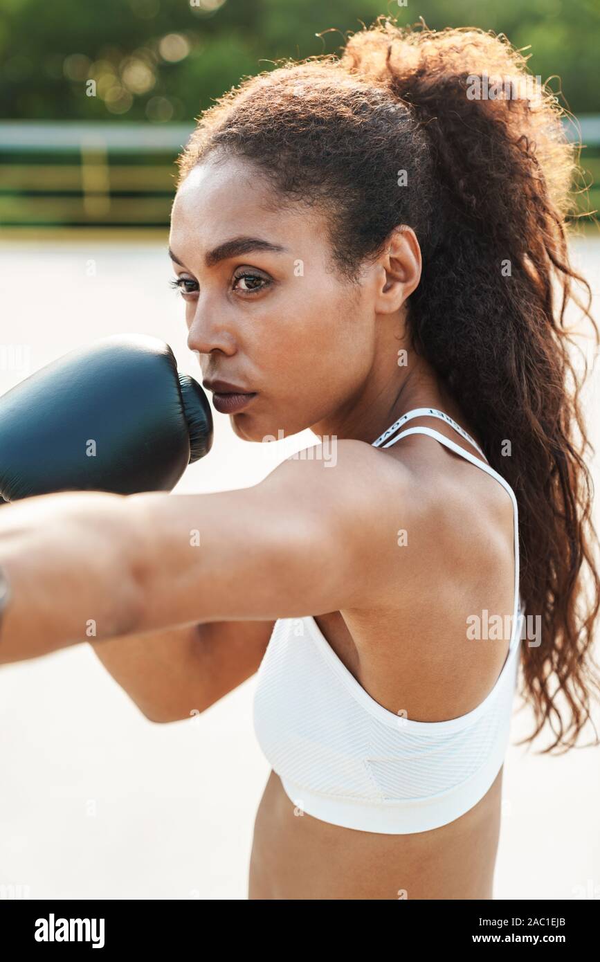 Mujer con guantes de boxeo y ropa deportiva