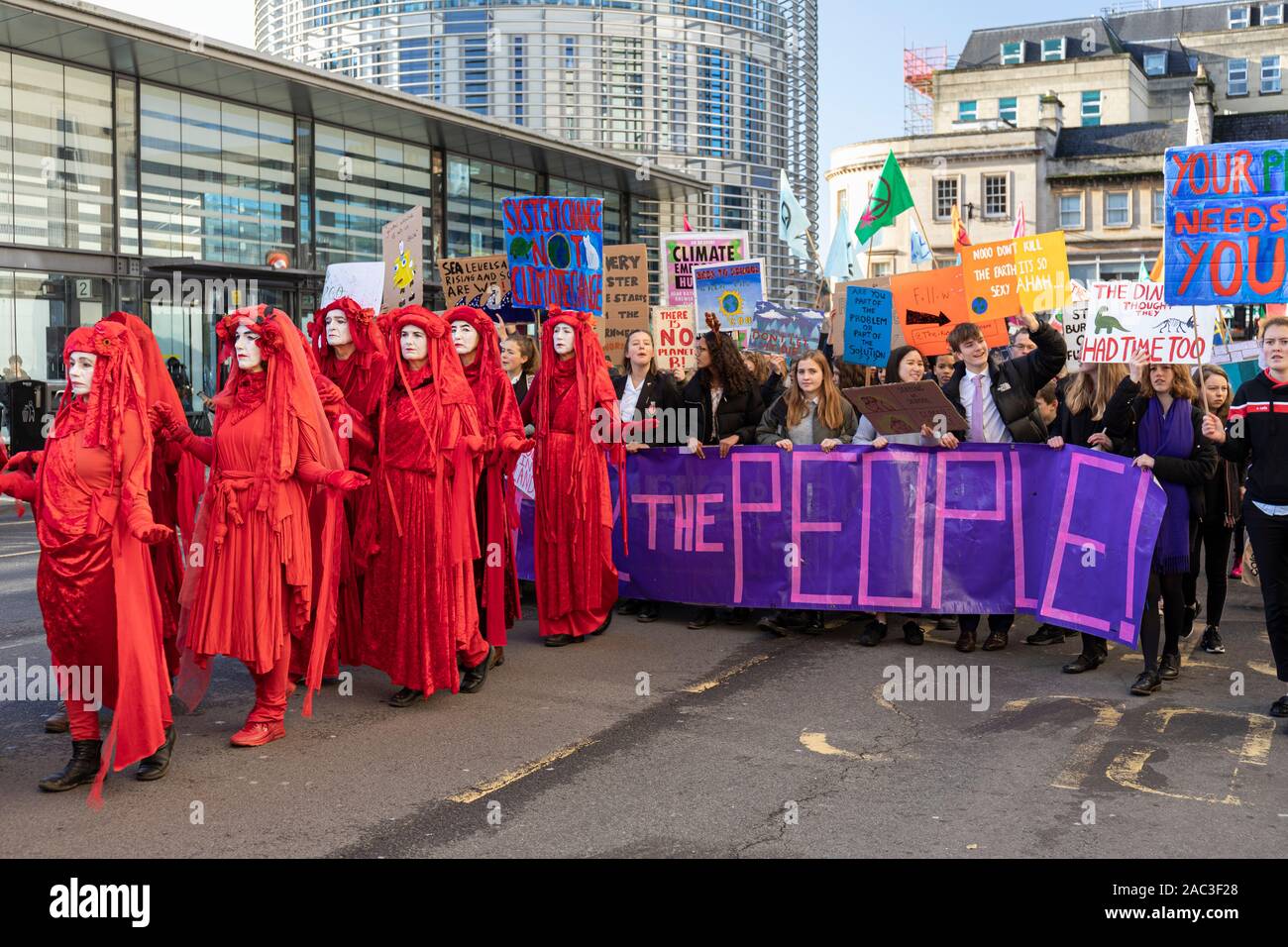Extinción Rebelión Roja los manifestantes contra el cambio climático de la brigada roja marchan a través del centro de la ciudad de Bath con la campaña de la Alianza Climática Juvenil de Bath para la acción. REINO UNIDO Foto de stock