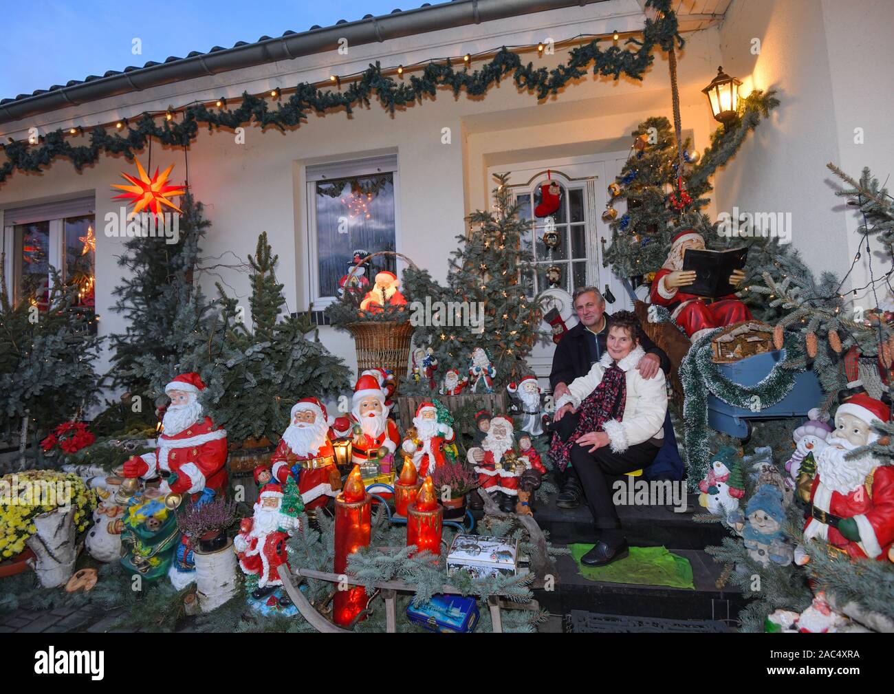 28 de noviembre de 2019, Brandenburgo, Straupitz: Gisela Liebsch y Gerd  Mörl sentarse delante de su casa entre muchas figuras y el muñeco de nieve  de Navidad. Donde quiera que usted mire -
