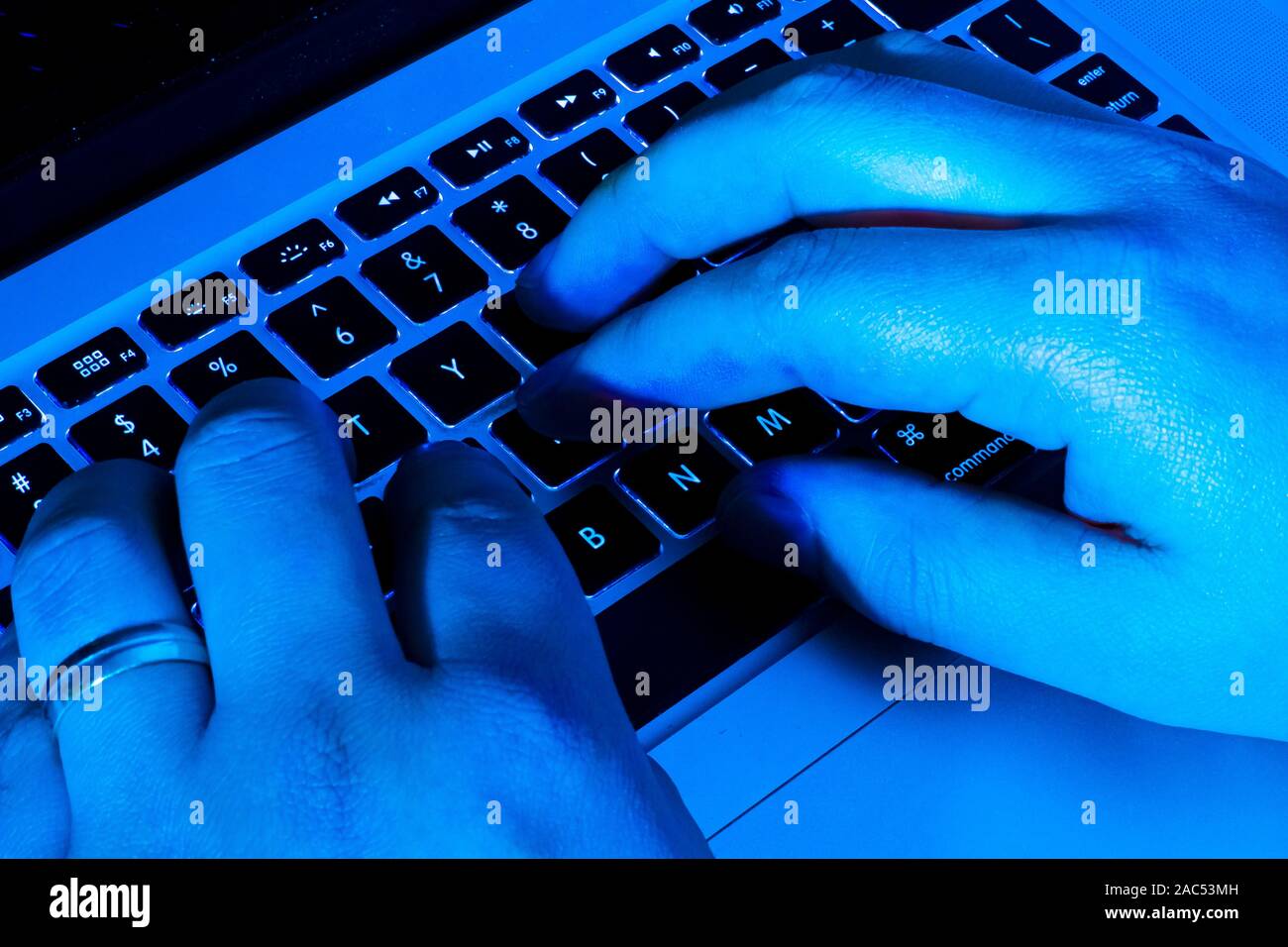 Una persona que escribe muy rápido en un ordenador portátil en la noche  Fotografía de stock - Alamy