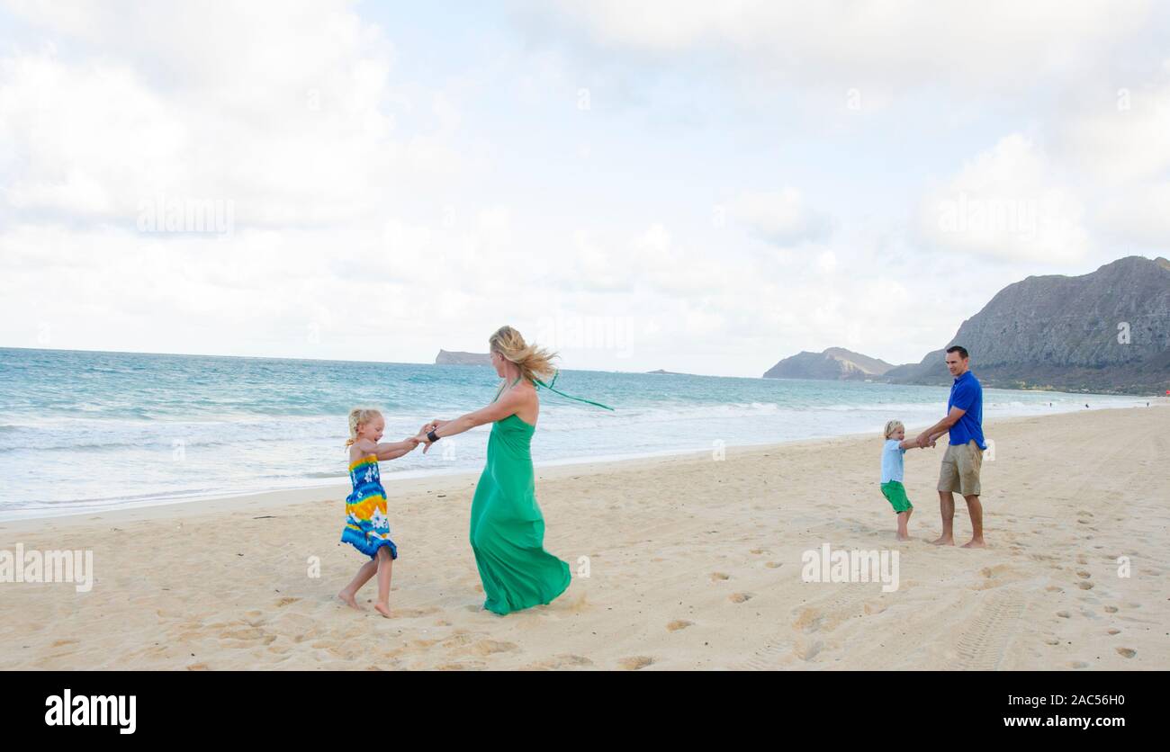 Una familia de cuatro personas jugando en Waimanalo Beach, O'ahu. Foto de stock