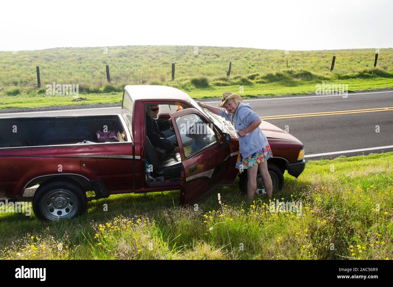 Una linda pareja de ancianos con un camión rojo a lo largo de pausa Saddle Road, Isla Grande. Foto de stock