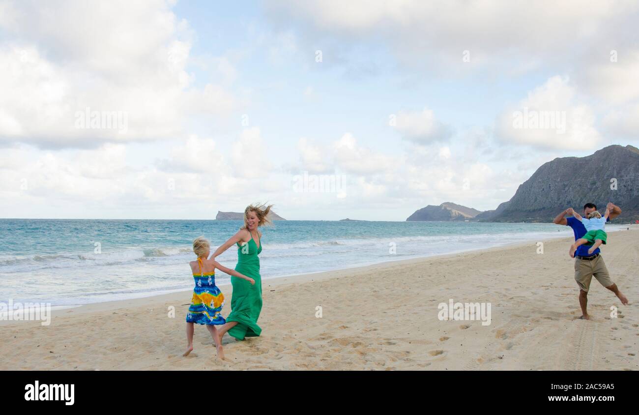 Una familia de cuatro personas jugando en Waimanalo Beach, O'ahu. Foto de stock