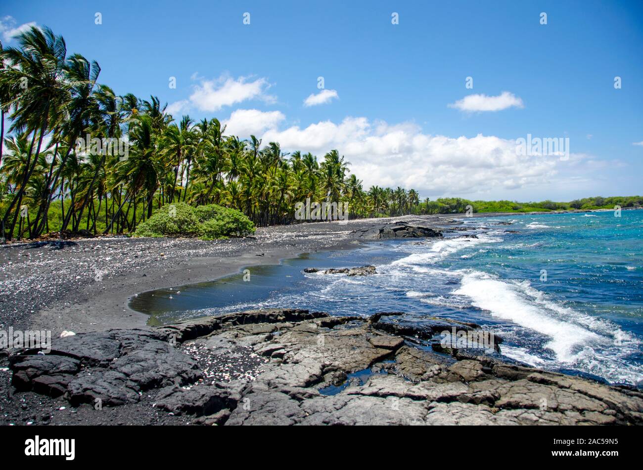 Mirando hacia el sur a lo largo de la mayoría de la playa de arena negra de Keawaiki Bay, al norte de kona, Hawai'i, una isla de 1859 erupción del volcán Mauna Loa fluyó en esta área, w Foto de stock