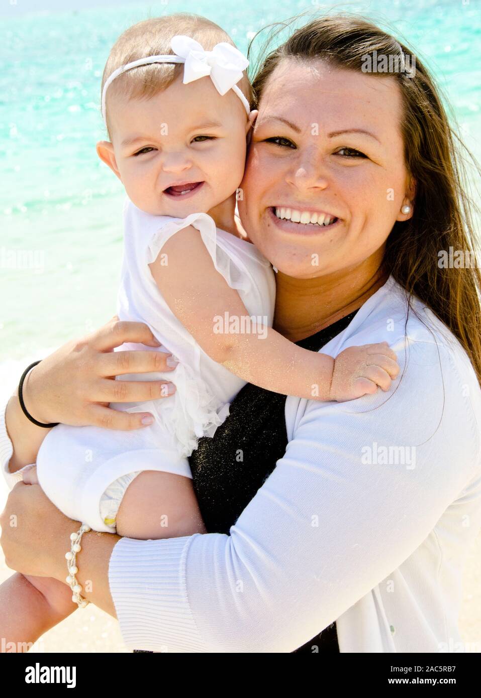 Mamá local Alyssa y baby Emma en la playa a la luz de la mañana. Foto de stock