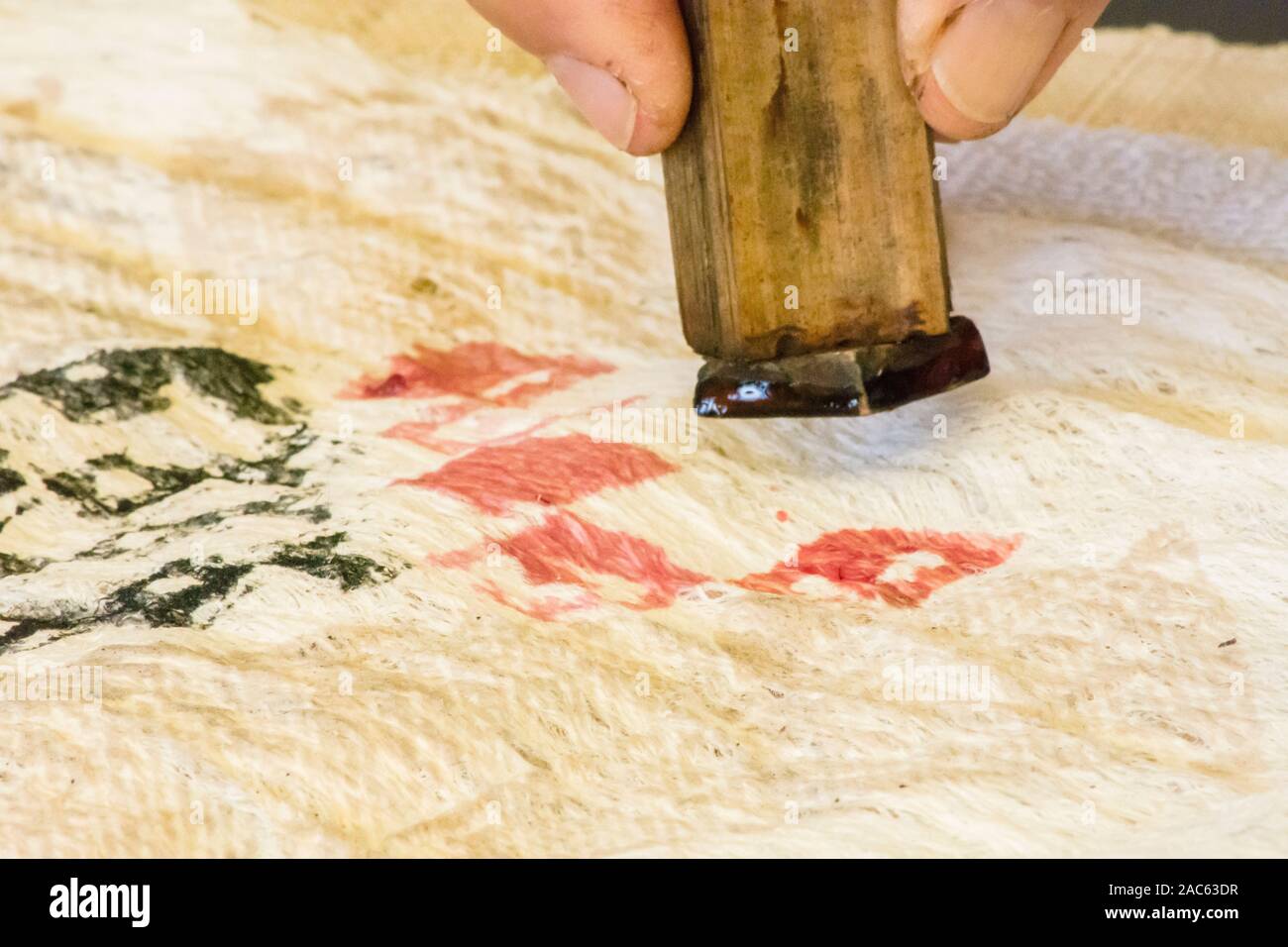 Kapa haciendo en la Isla Grande: Una kapa maker imprime diseños en kapa con un sello de madera impregnadas de tintes de plantas nativas. Foto de stock