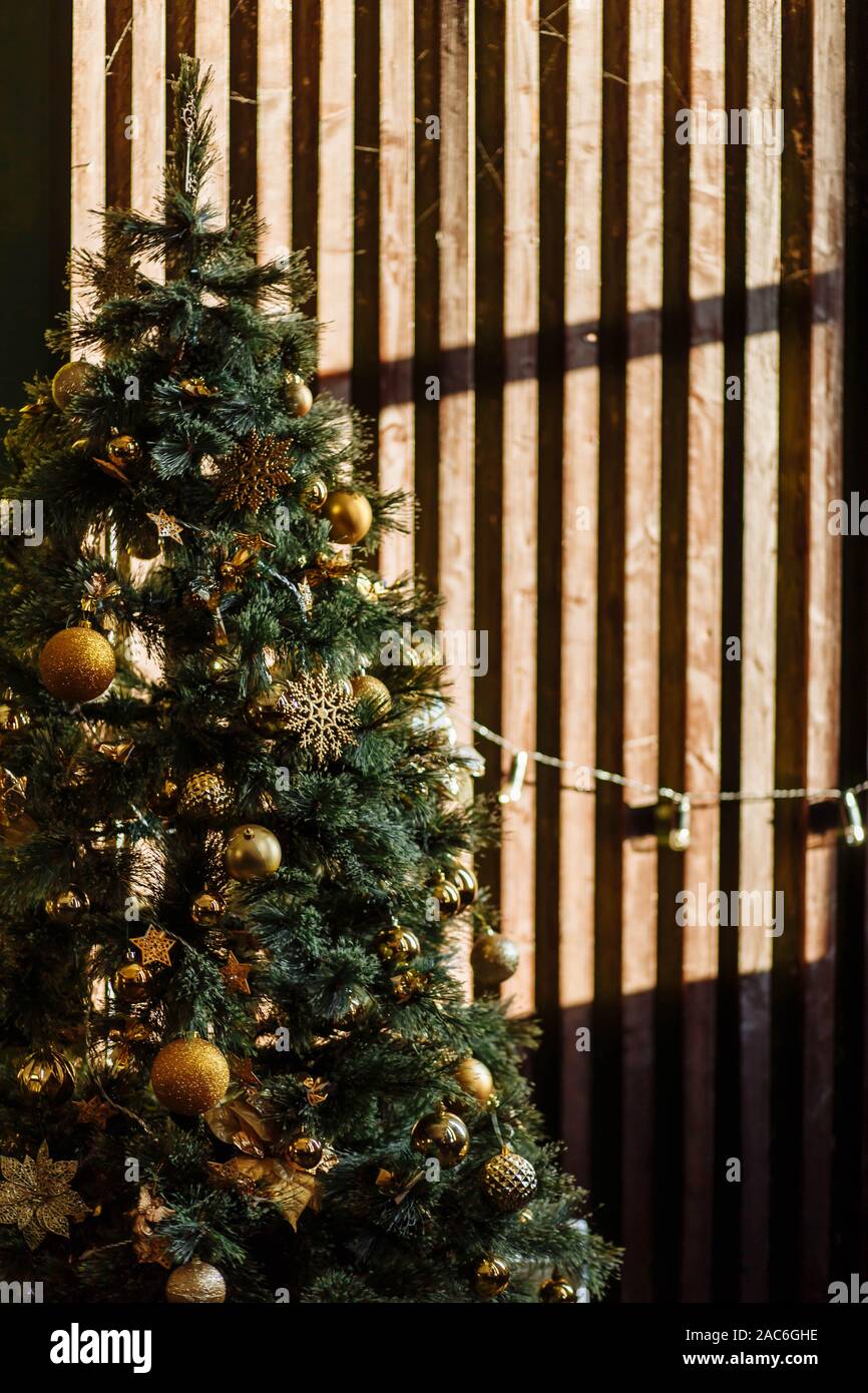 Árbol de Navidad verde decorado con ornamentos de conos de amarillo dorado  marrón cerca de la pared en la oscuridad con regalos cajas de madera piso  negro Fotografía de stock - Alamy