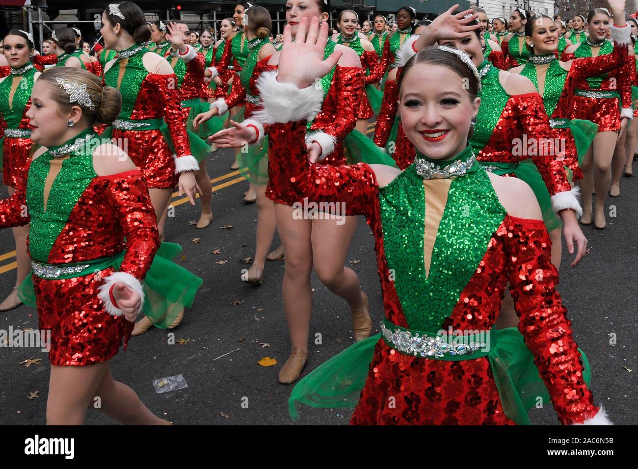 Artistas vestidos como Santa's helpers onda a las multitudes durante la 93ª Anual de Macy's Thanksgiving Day Parade en la Ciudad de Nueva York. Foto de stock