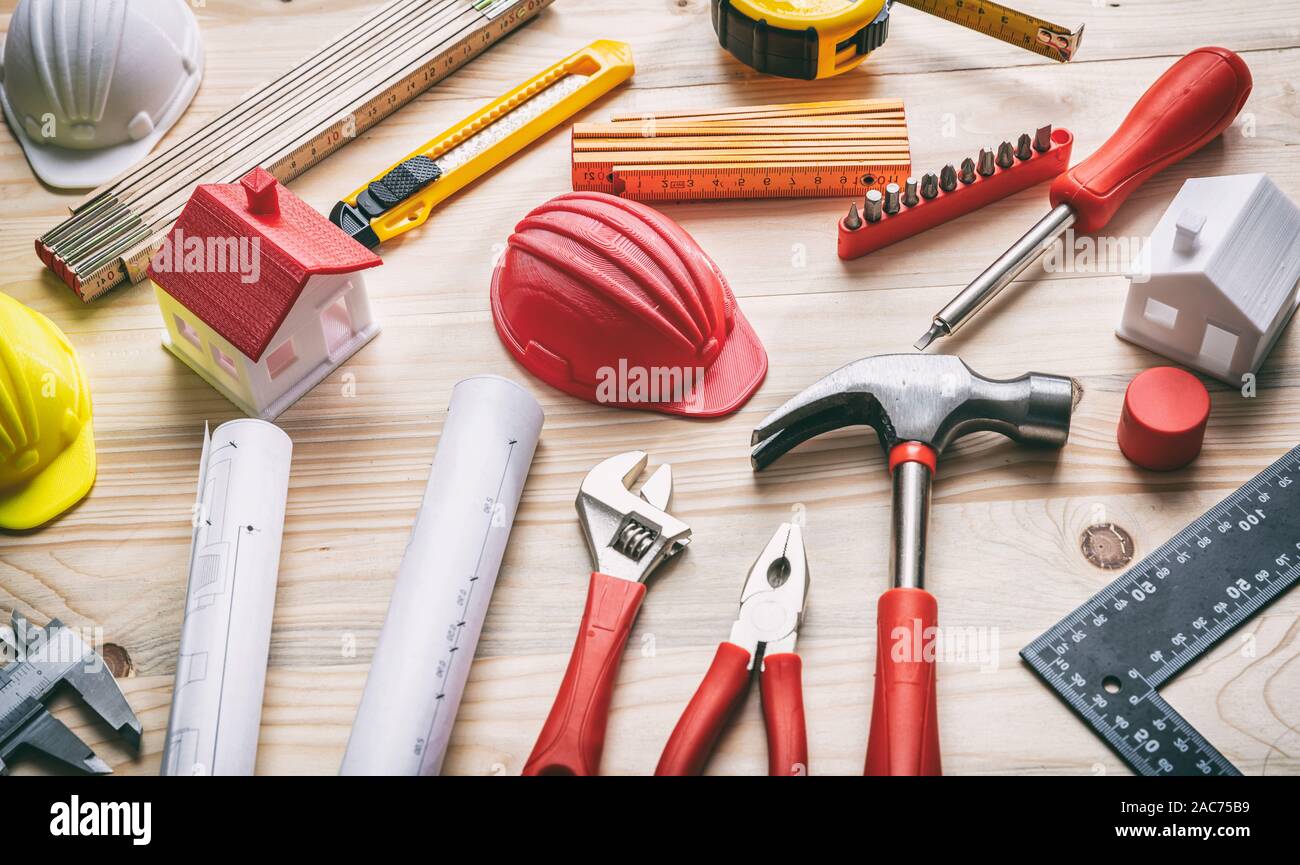 Concepto de construcción, renovación de la casa. Las herramientas de mano, sombreros duros y planos de proyectos sobre madera, Vista cercana Foto de stock