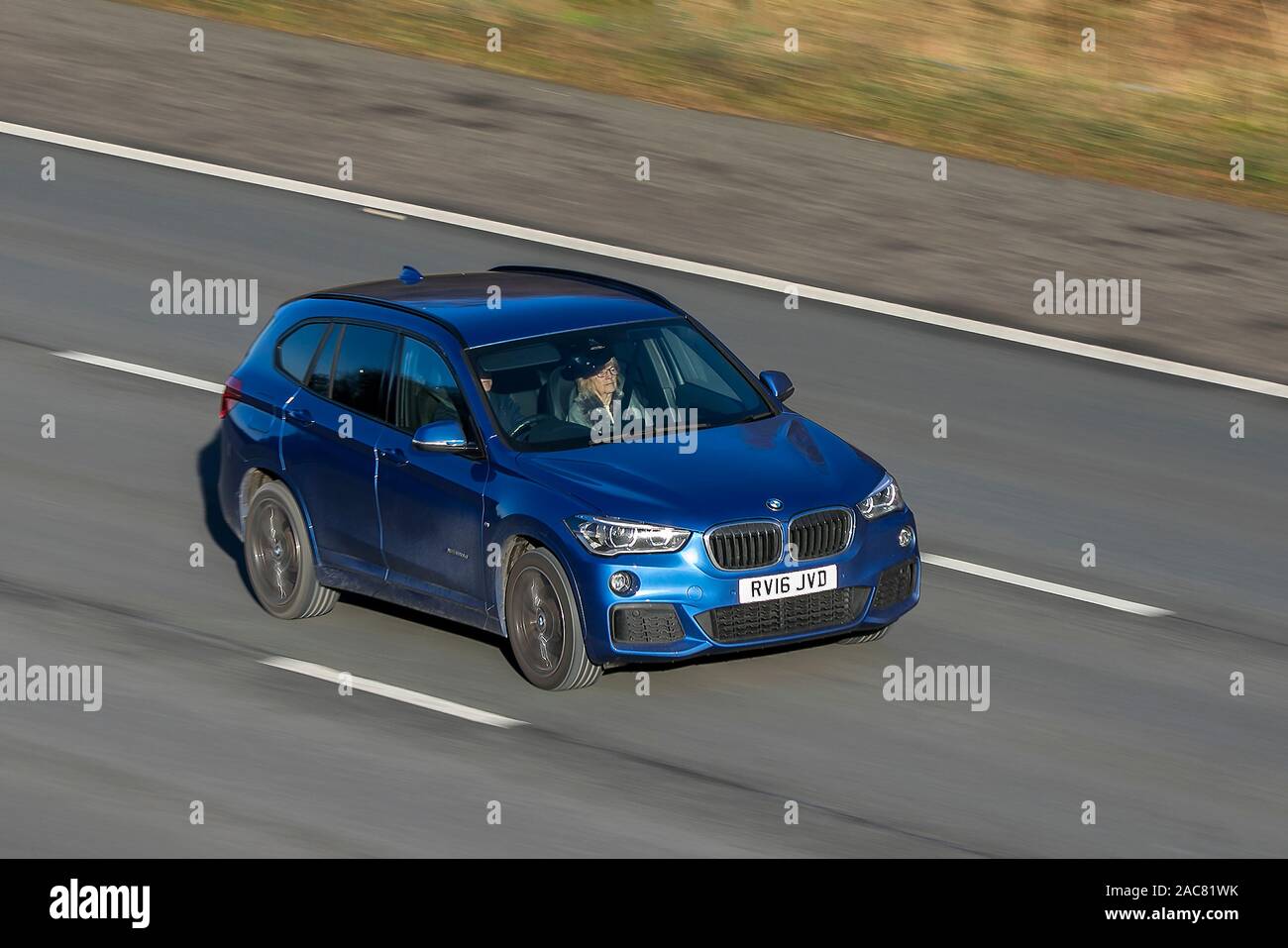 Coche en movimiento borrosa 2016 BMW X1 Xdrive20d M Sport Aut, viajando a la velocidad de la autopista M61 Cámara lenta velocidad de obturación el movimiento del vehículo Foto de stock