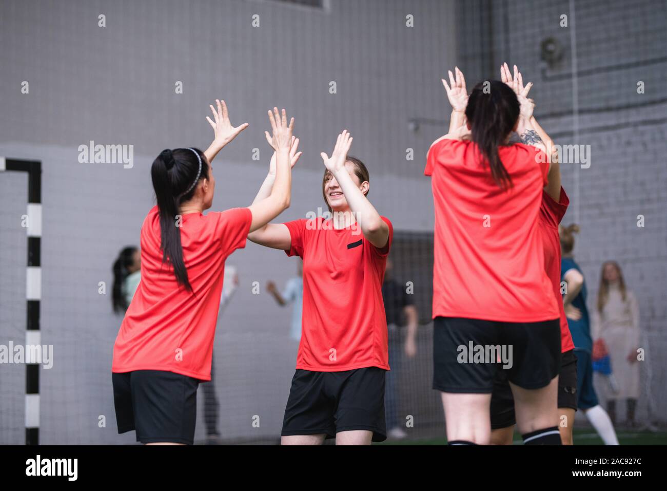 Equipo de niñas en deportes activos expresando uniforme el triunfo y la  victoria dando cada otros altos fives después del juego de fútbol  Fotografía de stock - Alamy