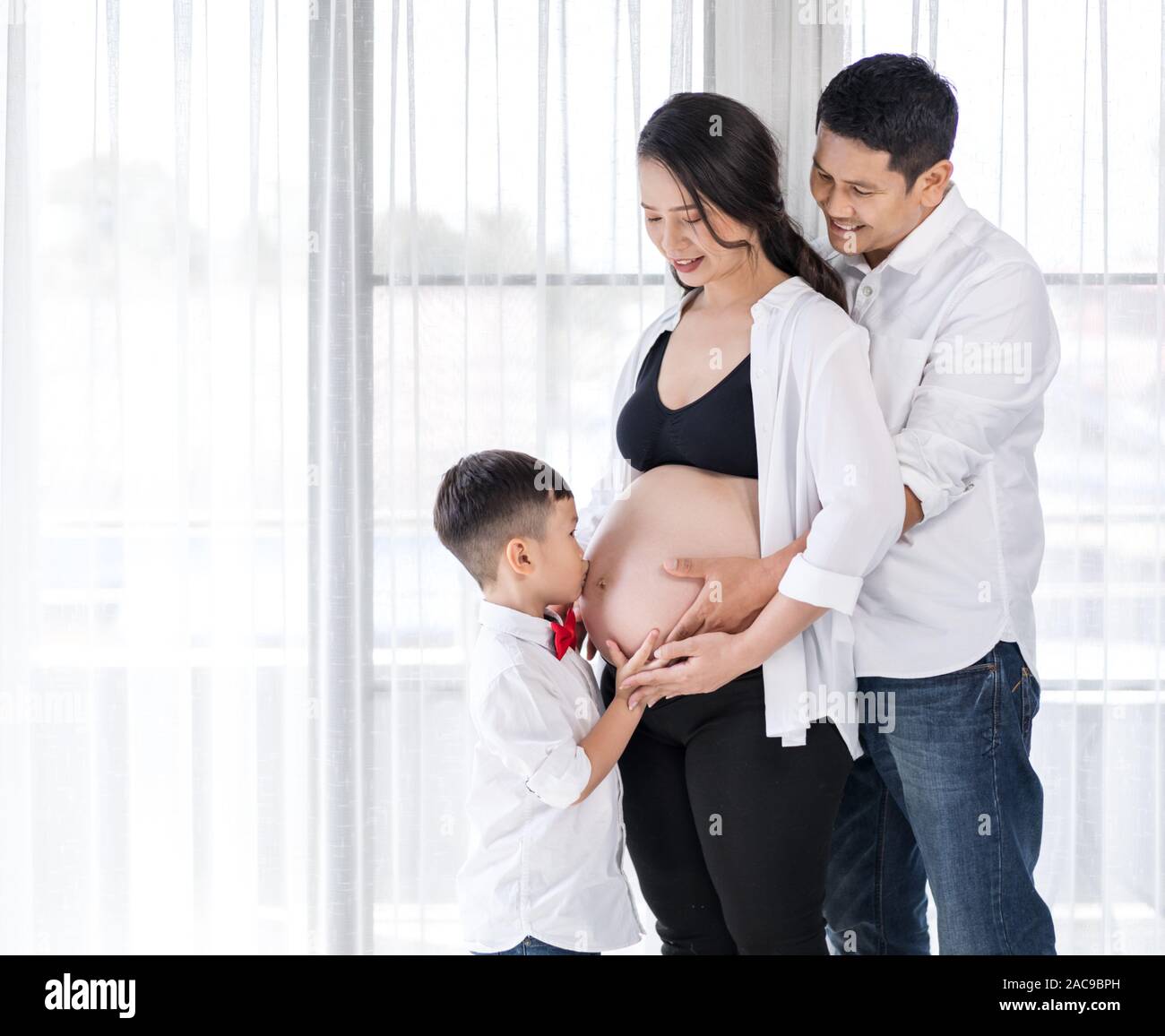 Concepto de familia feliz, la madre embarazada, padre e hijo besos  Fotografía de stock - Alamy