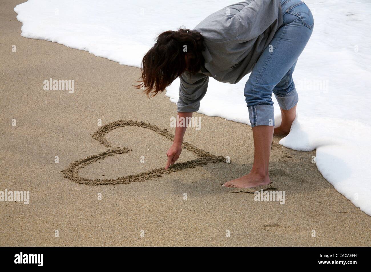 Estar enamorado - Pintura corazones en la playa Foto de stock