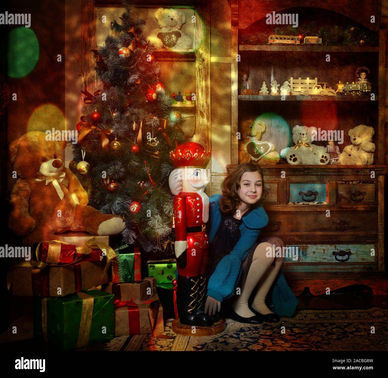 Niña 9-10 años sentados cerca del árbol de Navidad con regalos y juguete Cascanueces grandes luces de Navidad Mágica . Foto de stock