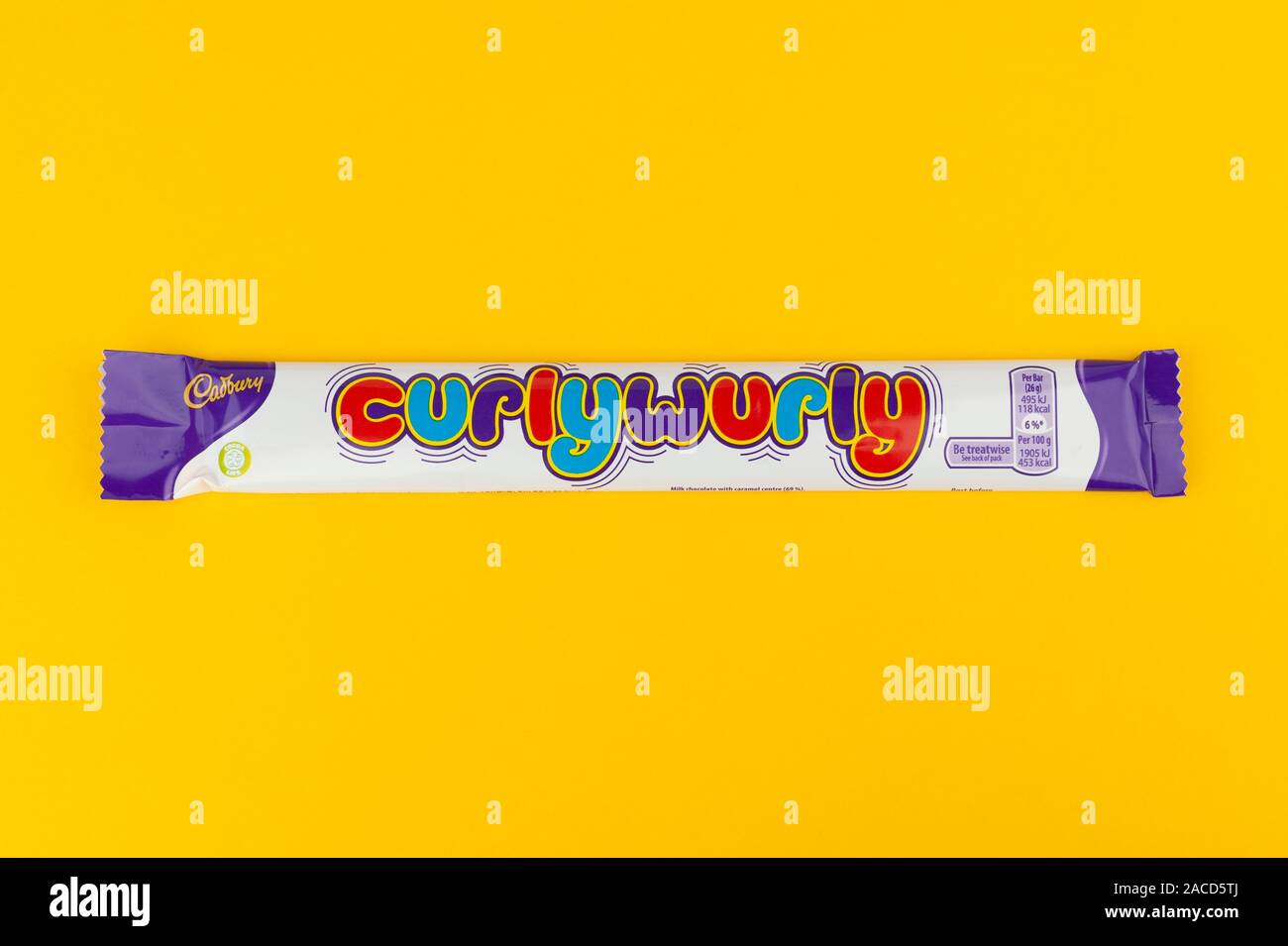 Una barra de chocolate Cadbury's Curly Wurly disparó sobre un fondo amarillo. Foto de stock