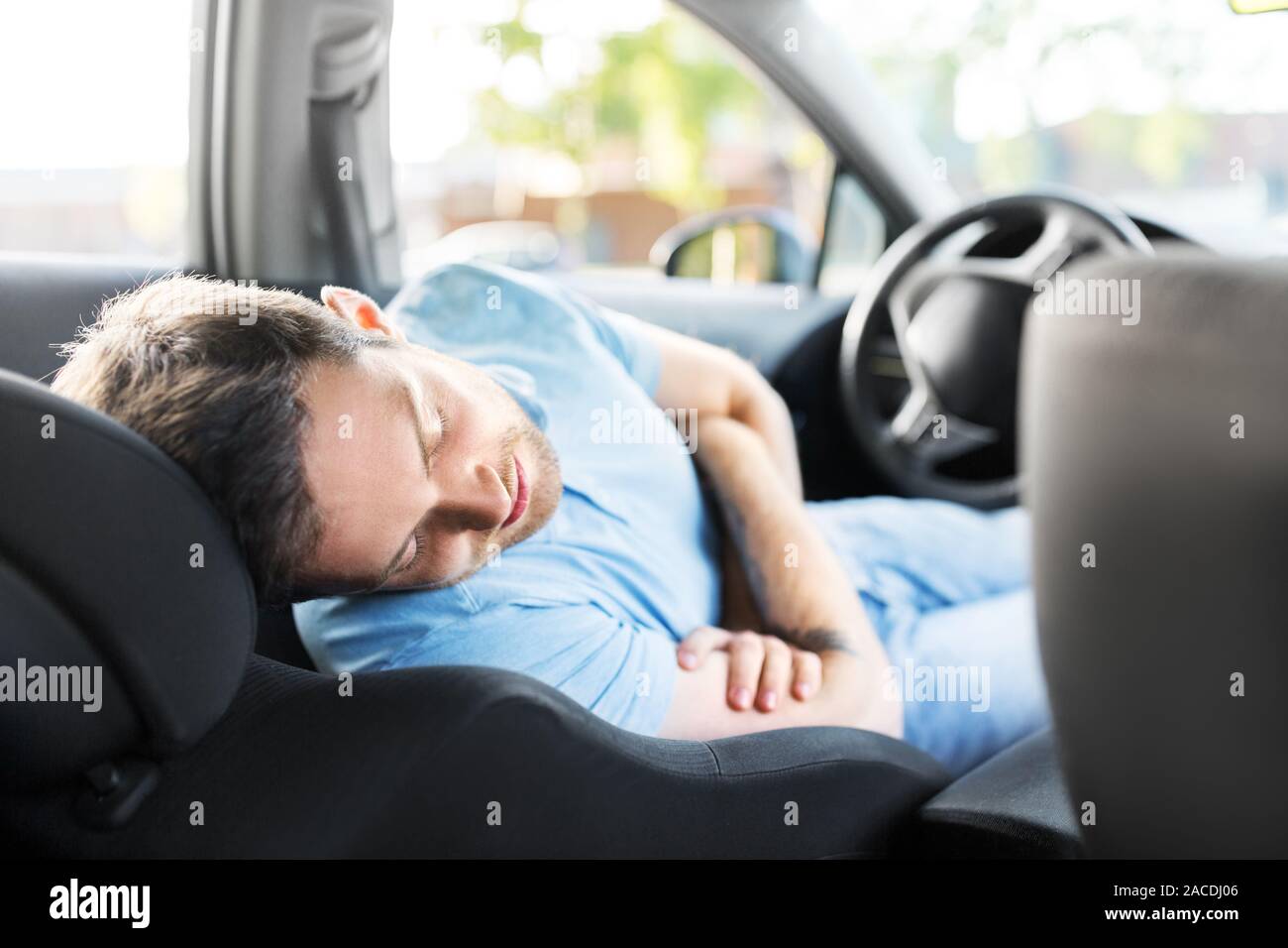 Hombre cansado o conductor durmiendo en el coche Foto de stock