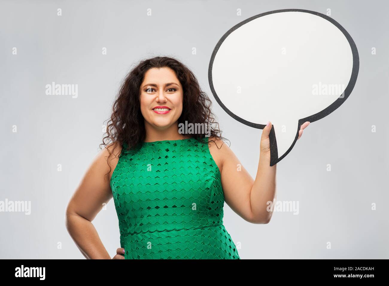 Feliz mujer de vestido verde celebración burbujas de voz Foto de stock