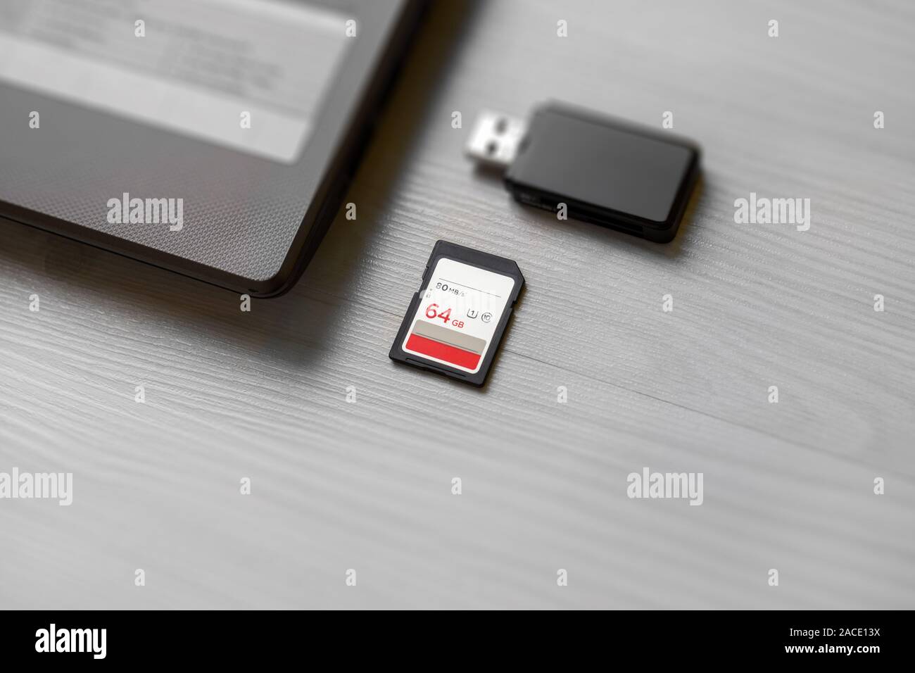 Tarjeta de memoria SD en la mesa junto al ordenador portátil y lector de  tarjetas Fotografía de stock - Alamy