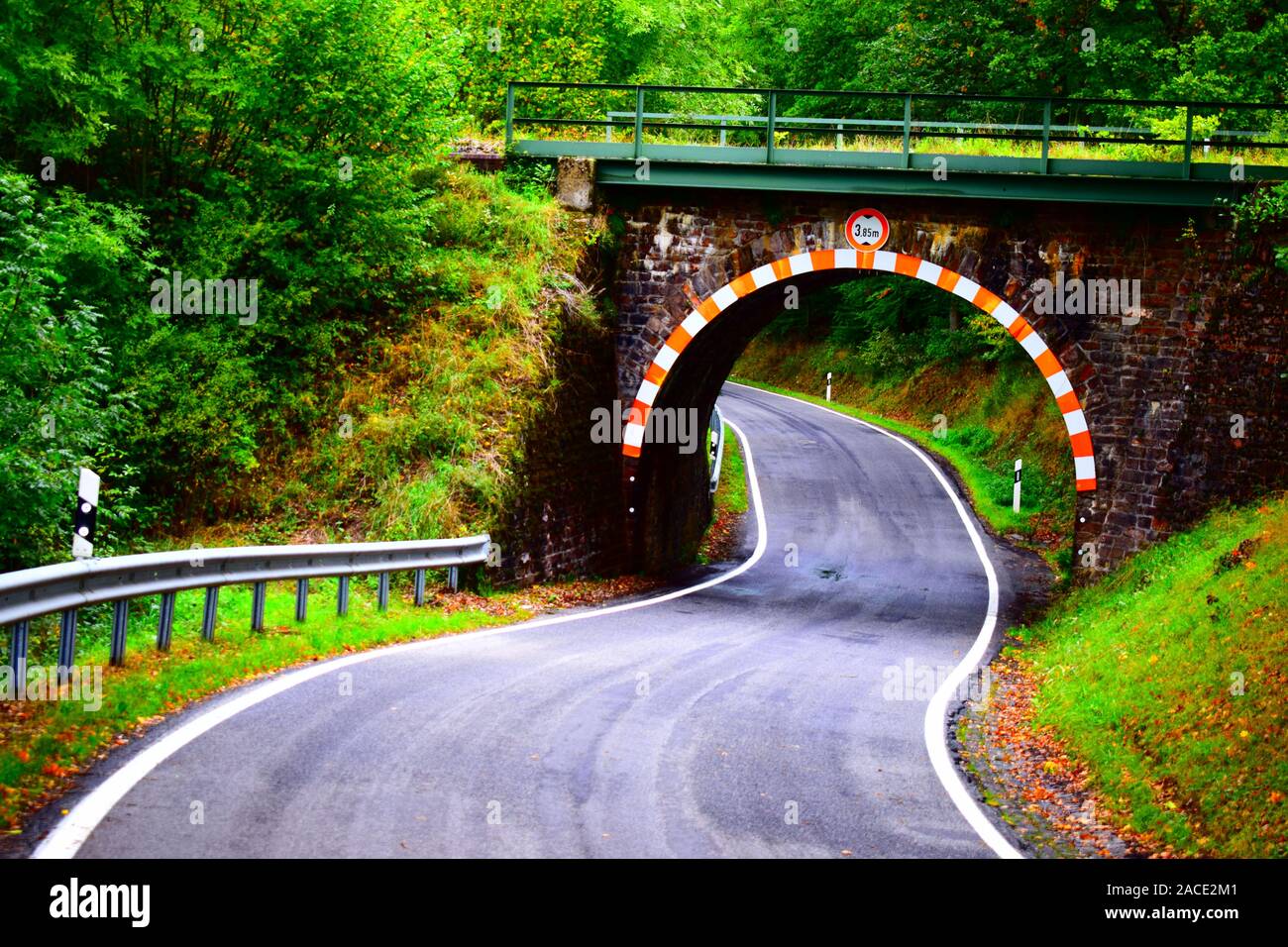 Viejo Puente ferroviario a través de una carretera estrecha Foto de stock