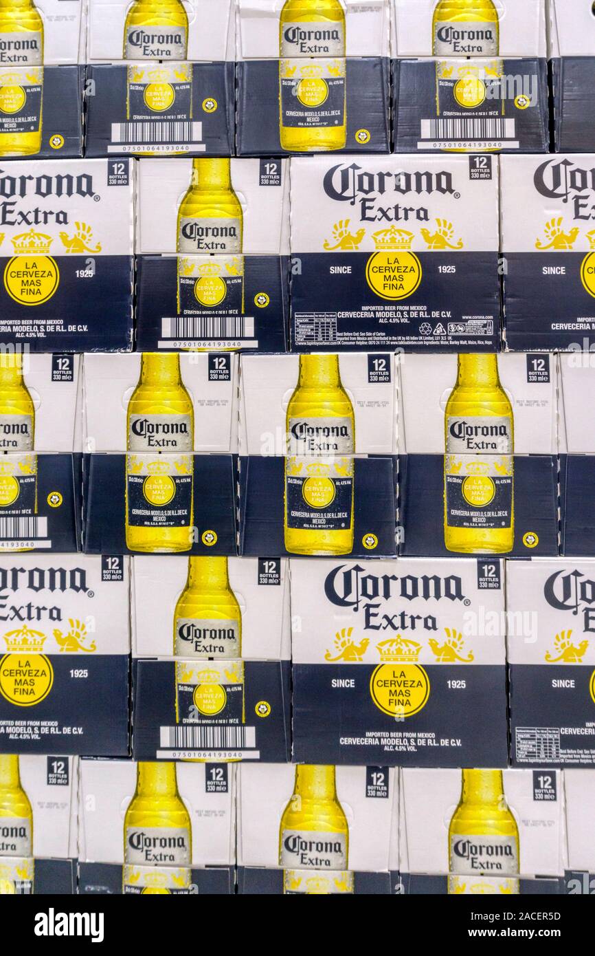 Cajas apiladas que contienen botellas de cerveza Corona Extra para la venta en un supermercado. Foto de stock