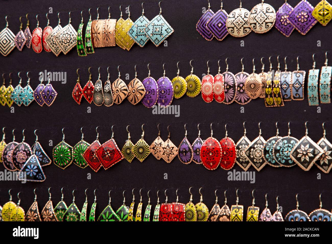 Un conjunto de gran variedad de aretes hechos en el estilo turco nacional  en el mostrador de una tienda de joyas. Muchos coloridos aretes para la  venta en la calle exterior m