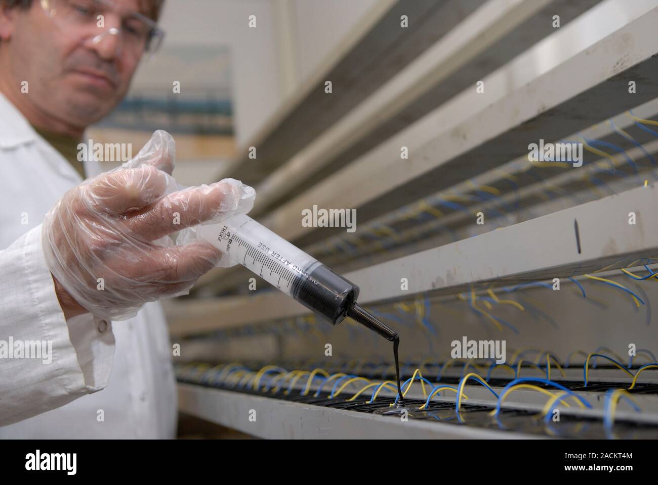 Línea de montaje de fabricación, se inyecta resina para asegurar y