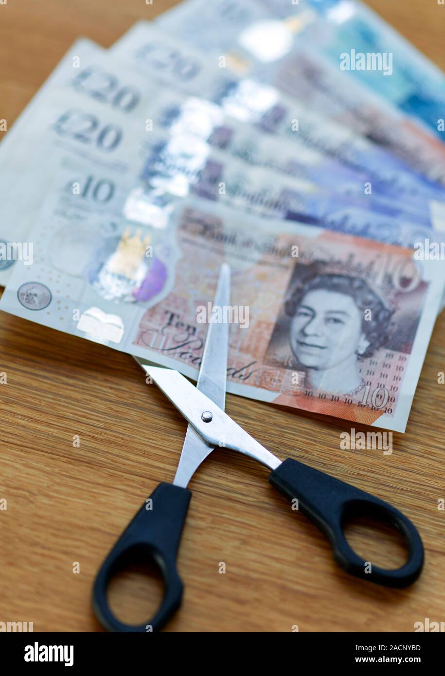 Concepto de tijeras de corte nota de diez libras Foto de stock