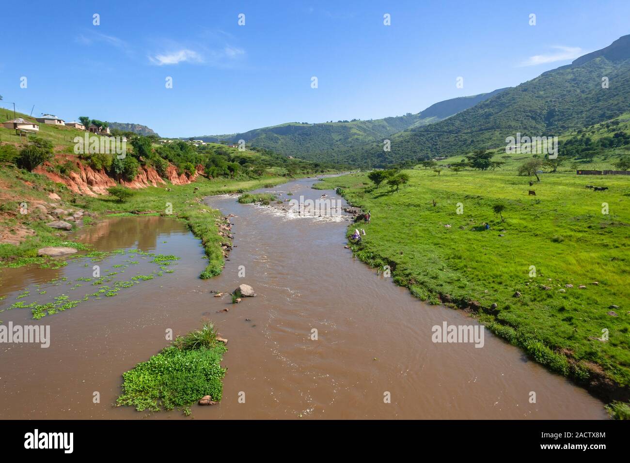 Con vistas a río que fluye el agua en las zonas rurales valle con colinas circundantes verano verde paisaje yermo. Foto de stock