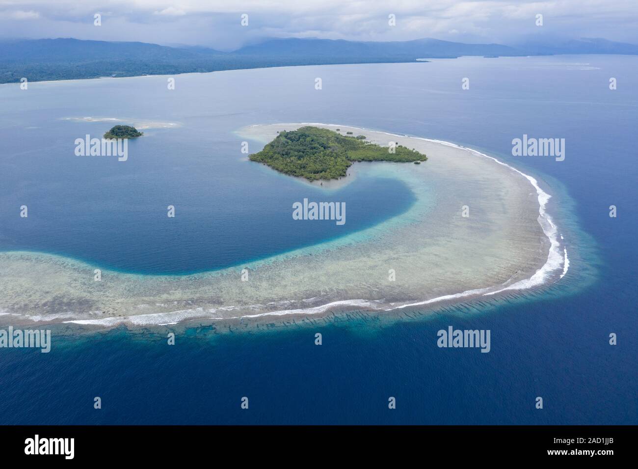 Una vista de pájaro muestra el lavado tropical del Océano Pacífico en el borde de un arrecife de coral de devolución a lo largo de la costa de Nueva Bretaña, Papúa Nueva Guinea. Foto de stock