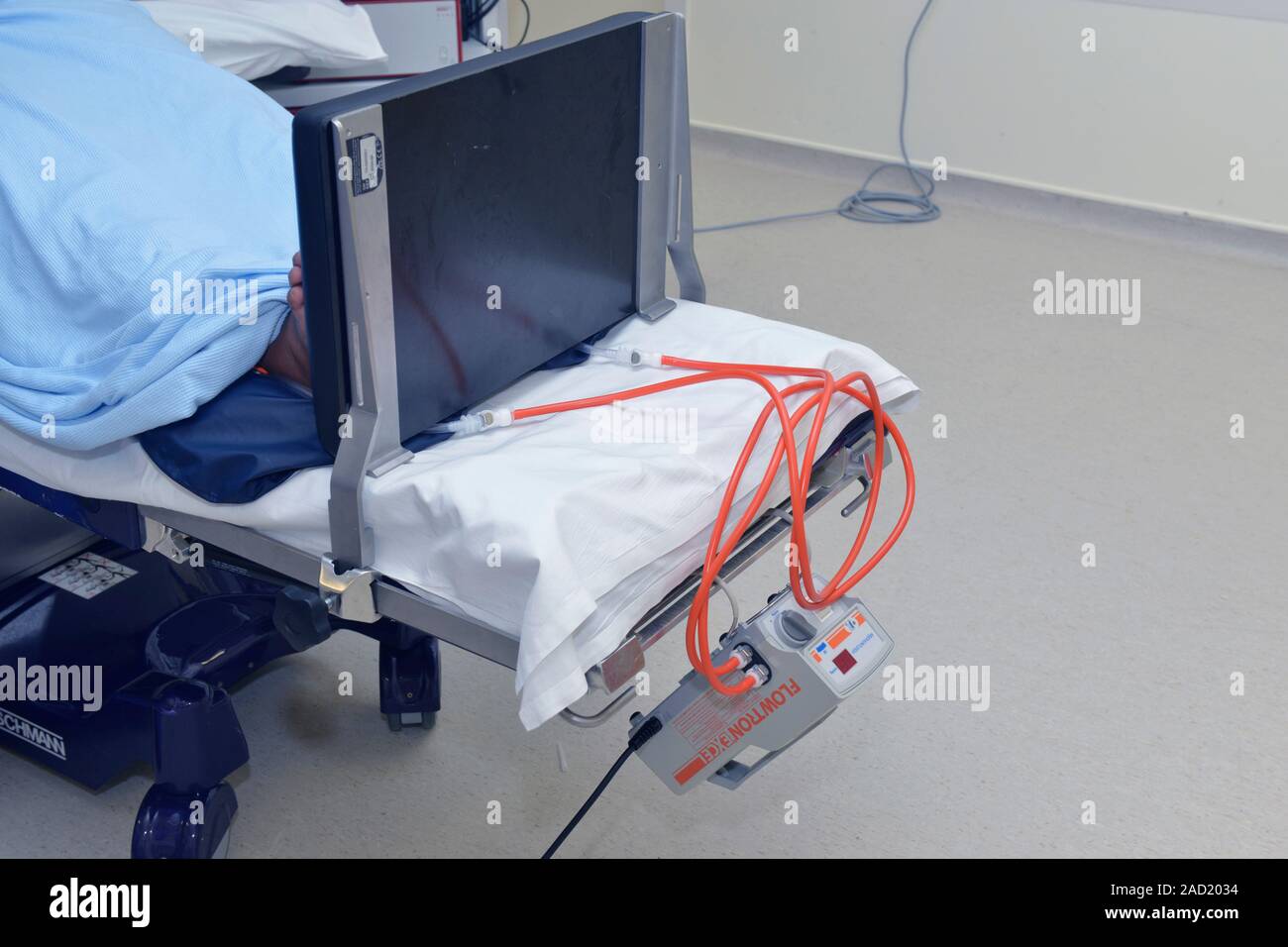 Compresión neumática intermitente (IPC) la bomba al final de la cama de un  hospital. La bomba está conectada al mangas inflables en las piernas del  paciente. Se infl Fotografía de stock -