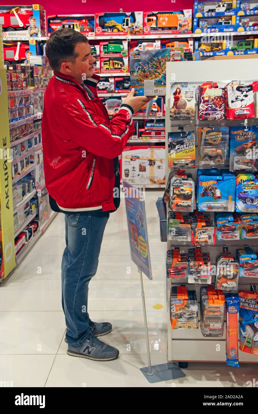 El hombre escoger juguetes para niños en la tienda. Papá comprando juguetes  para el hijo. La compra de juguetes en la tienda de juguetes. Tienda de  juguetes. Dentro de la tienda de