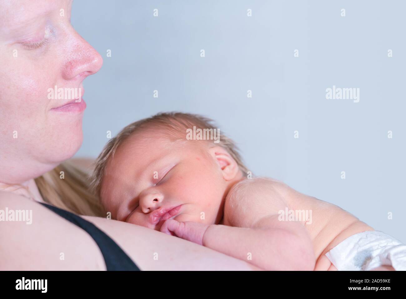 Bebé niña bebé dormido y descansando sobre Su mamá Foto de stock