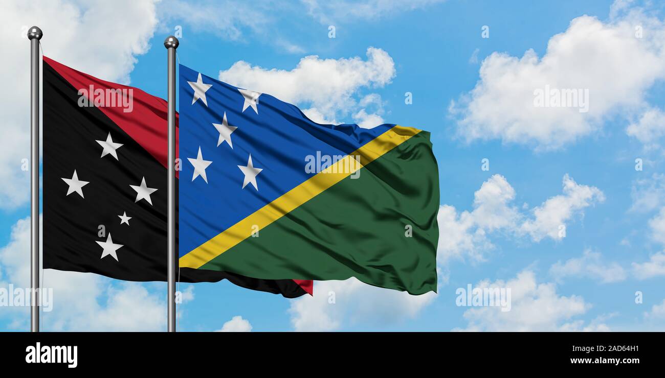 Papua Nueva Guinea y las Islas Salomón ondear la bandera en el viento  contra un blanco azul cielo nublado juntos. Concepto de diplomacia y  relaciones internacionales Fotografía de stock - Alamy