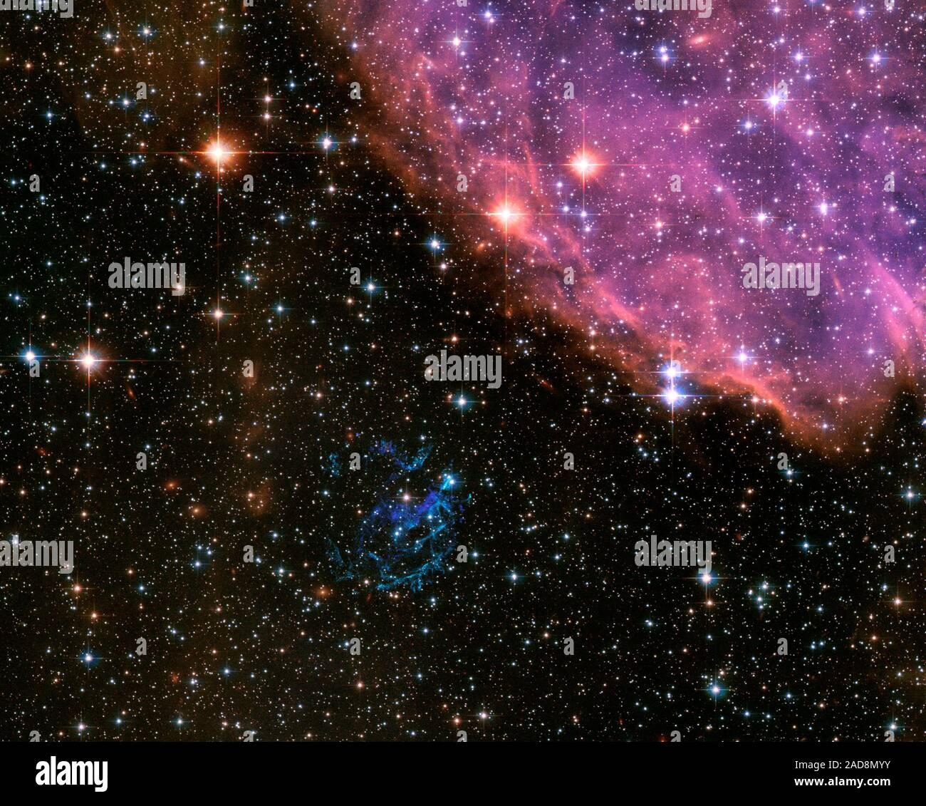 Con reminiscencias de un EE.UU. Julio 4 Celebración del Día de la independencia, aquí está una imagen del Telescopio Espacial Hubble de la NASA de una explosión cósmica que es muy similar a la de los fuegos artificiales de la tierra. En la galaxia vecina, la pequeña Nube de Magallanes, una estrella masiva ha estallado como una supernova y comenzado a disiparse su interior en una espectacular exhibición de coloridos filamentos. Los remanentes de supernova (SNR), conocida como "E0102" para abreviar, es el azul verdoso de escombros shell justo debajo del centro de la imagen del Hubble. Su nombre se deriva de su catalogado de colocación (o coordenadas) en la esfera celeste. Más formalmente conocida Foto de stock