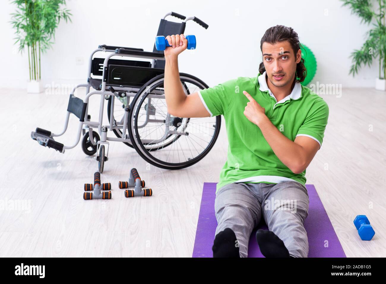 Joven en silla de ruedas hacer ejercicios en interiores Foto de stock