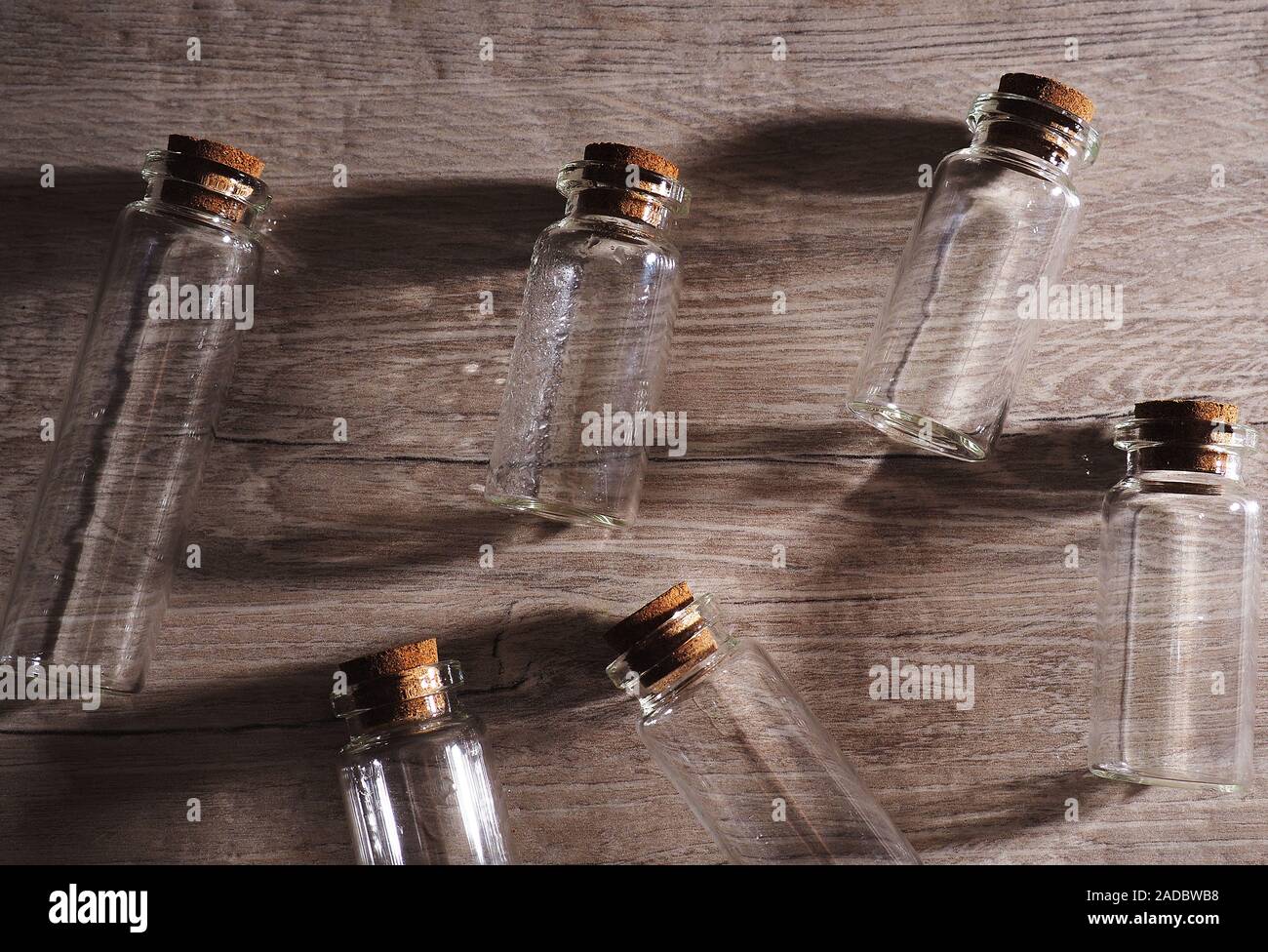 Botellas de vidrio pequeñas con tapa de corcho. Burbujas vacías en luz  contorneada sobre fondo de madera, gran banner, espacio para el diseño  Fotografía de stock - Alamy